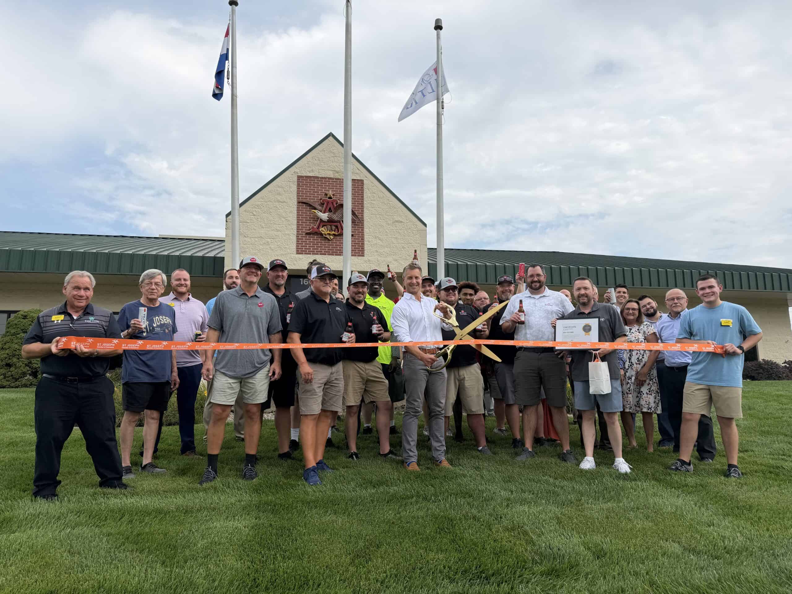 Group holds ribbon in front of building