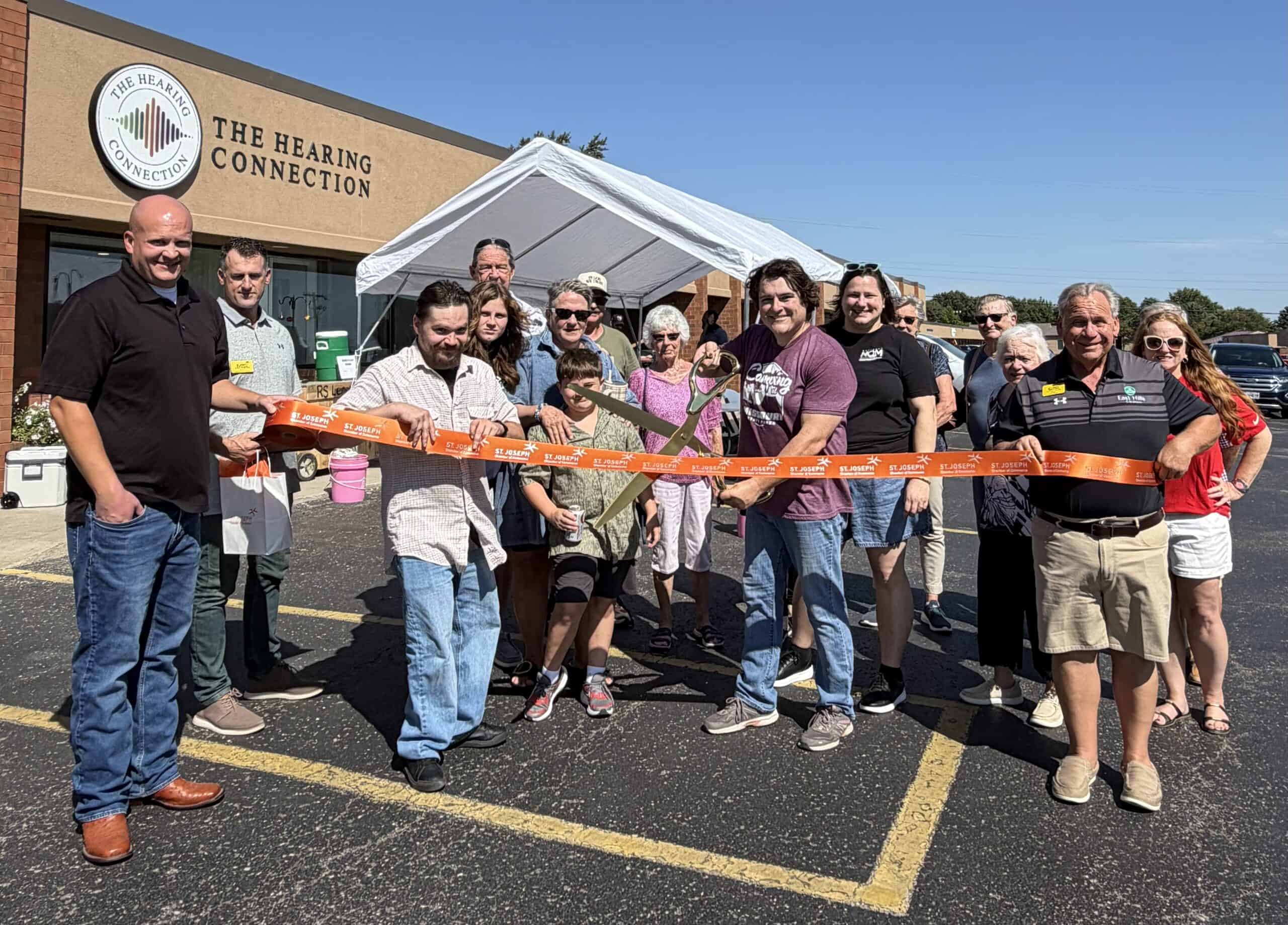 Group of people at ribbon cutting event outside Hearing Connection in St. Joseph, MO.